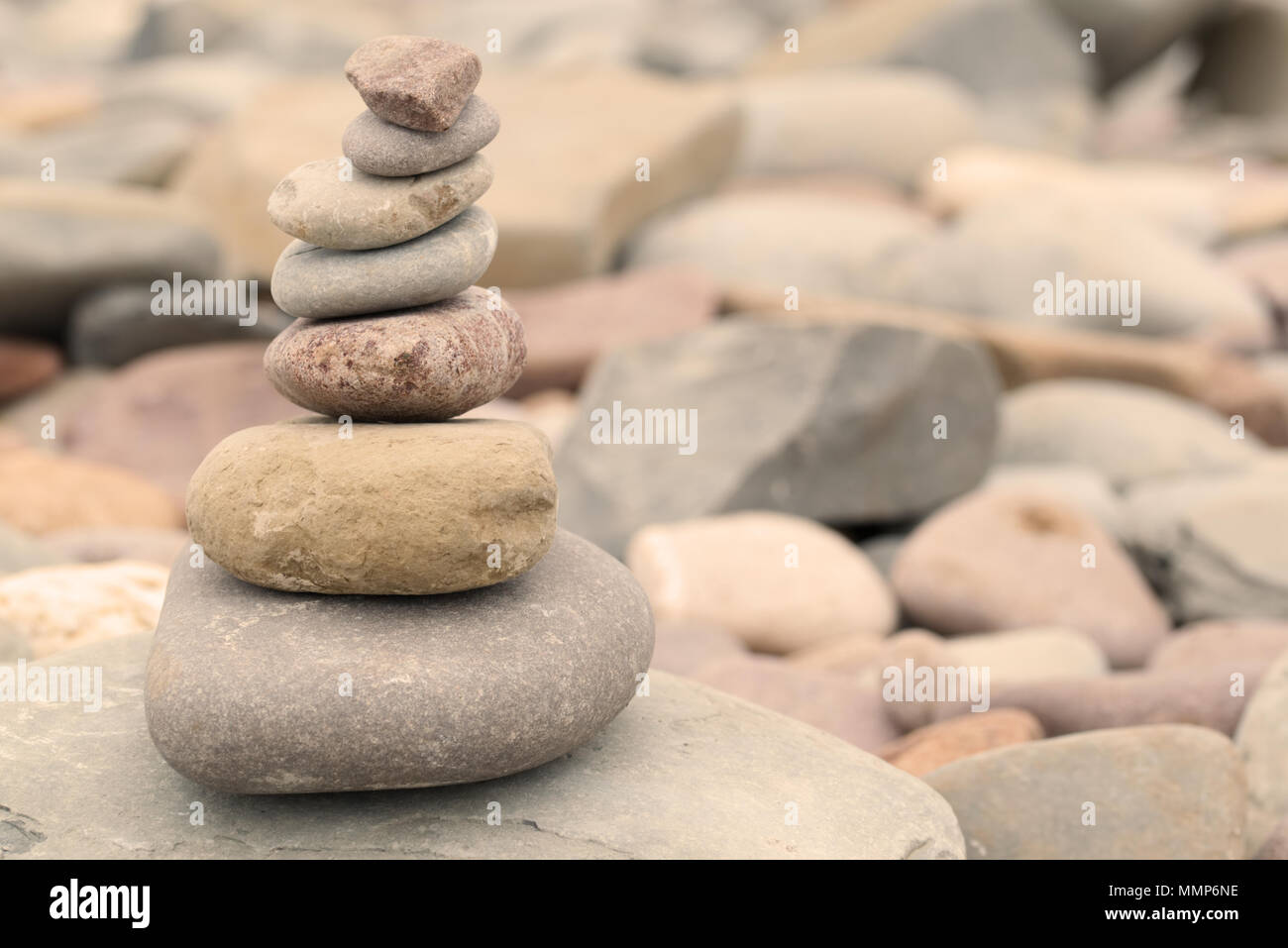 Montón de piedras en una playa de guijarros en la cálida luz del atardecer. Calma pacífica concepto zen Foto de stock