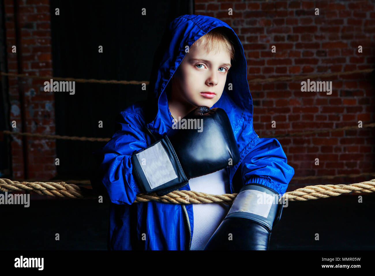 Lindo rubia niño boxer con guantes negros y bata en el anillo Fotografía de  stock - Alamy