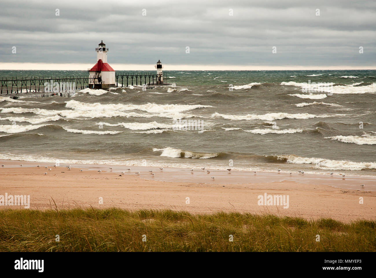 Un pequeño faro en el embarcadero en St. Joeseph Michigan durante clima stromy con ondas del lago Michigan golpeando contra ella. Foto de stock