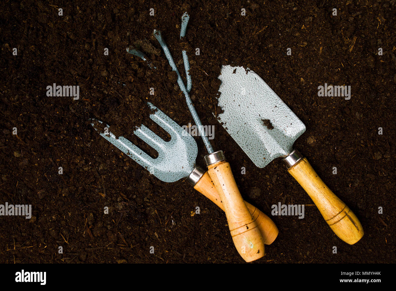 Herramientas de jardinería en el fértil suelo vista superior Foto de stock