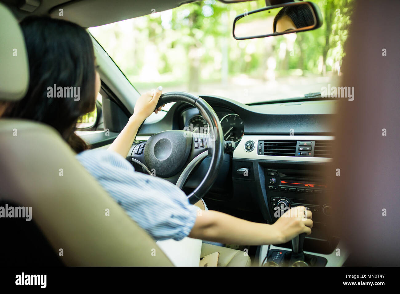 Mujer elegante seguro conducir un automóvil en la ciudad disfrutando del  tráfico y la buena música de estación de radio Fotografía de stock - Alamy