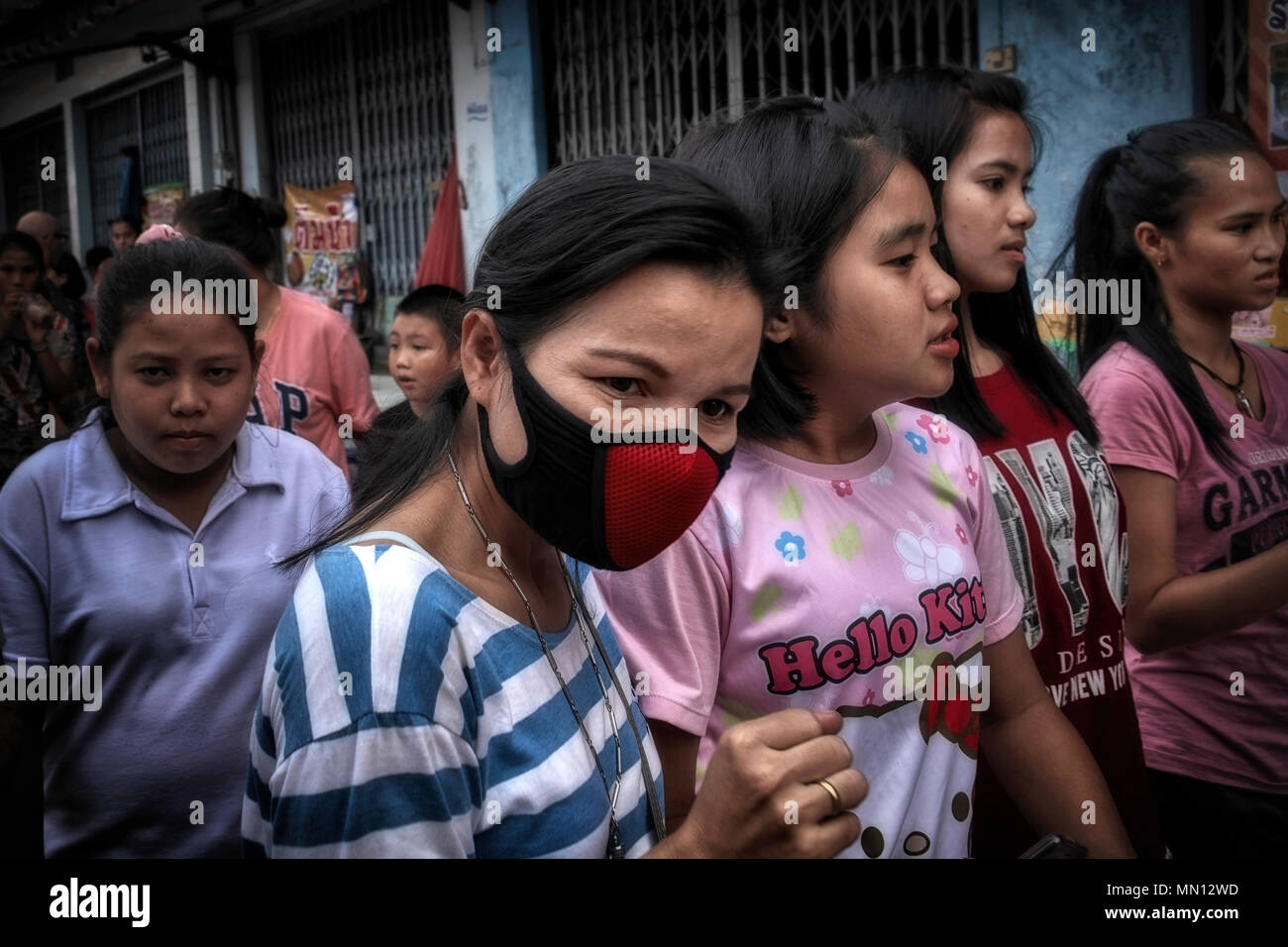 Mascarilla facial para mujer. Mujer que lleva una máscara anticontaminación en un concurrido mercado callejero asiático. Tailandia S. E. Asia Foto de stock