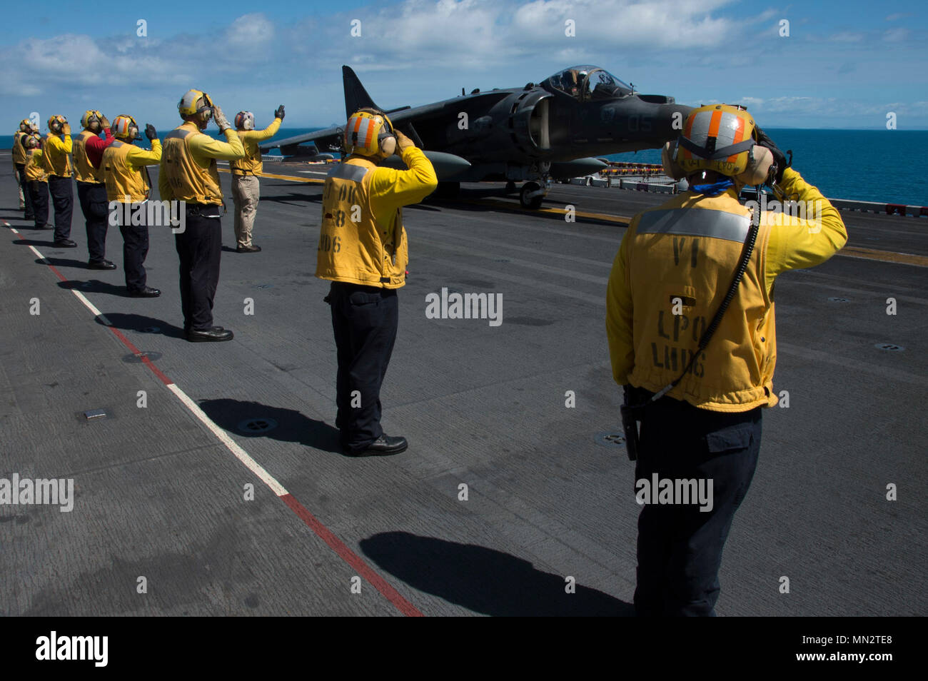 170822-N-RU971-294 MAR DEL CORAL (22 de agosto, 2017) departamento de aire marineros saludan al piloto de un avión AV-8B Harrier, asignado a la "Tomcats" del escuadrón de ataque marino (VMA) 311, antes de que despega desde la cubierta de vuelo del buque de asalto anfibio USS Bonhomme Richard (LHD 6). VMA-311 concluye su "Farewell Tour" con el Bonhomme Richard Expeditionary Strike Group (HRB ESG) y el 31º Grupo de ataque Expedicionaria de la Marina (MEU) como las transiciones de ESG A F-35B Lightning II Joint Strike Fighters en el invierno de 2017. Bonhomme Richard, buque insignia de la HRB ESG, está operando en el Pacífico Indo-Asia volver Foto de stock