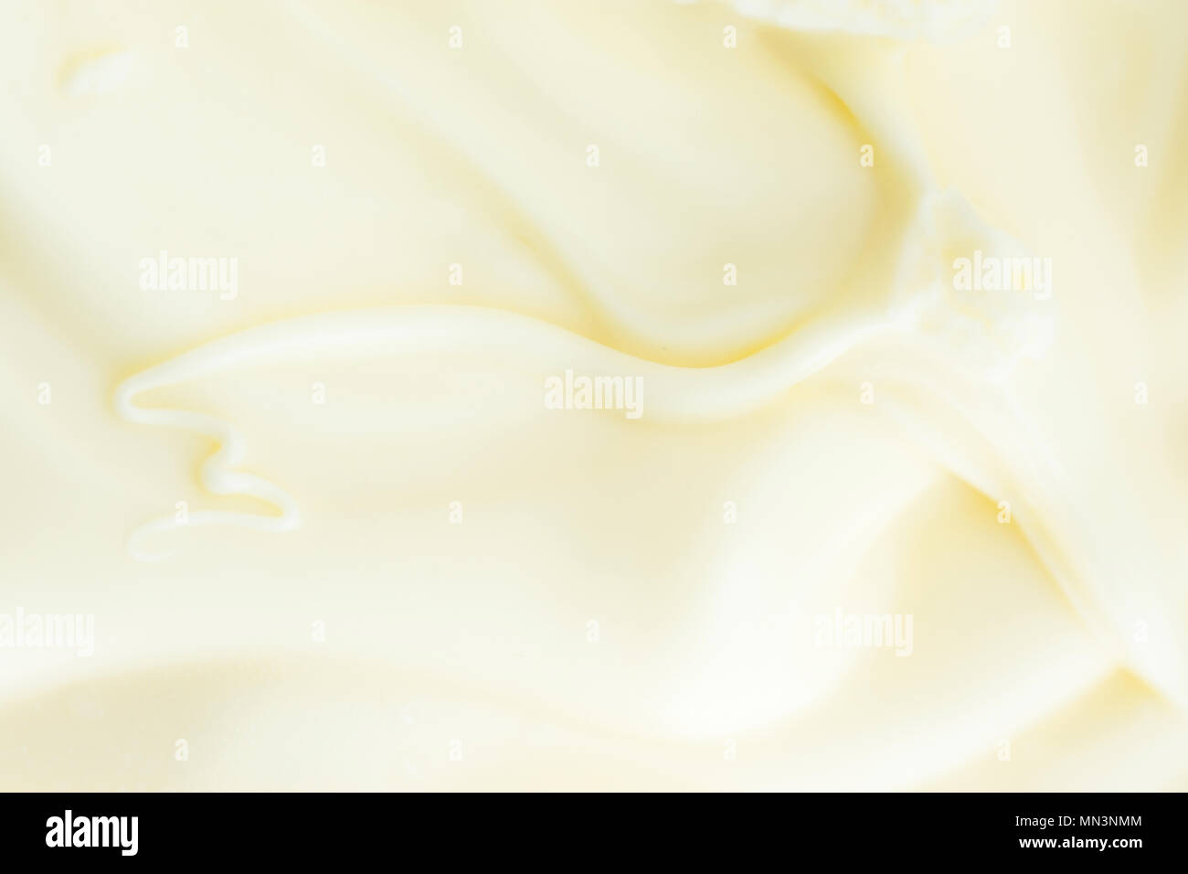 Mantequilla cremosa textura sedosa suave con Hermosos remolinos. Luz de color amarillo pastel. Póster de alimentos de fondo. Calorías grasas Dairy Productos Orgánicos. Copia S Foto de stock