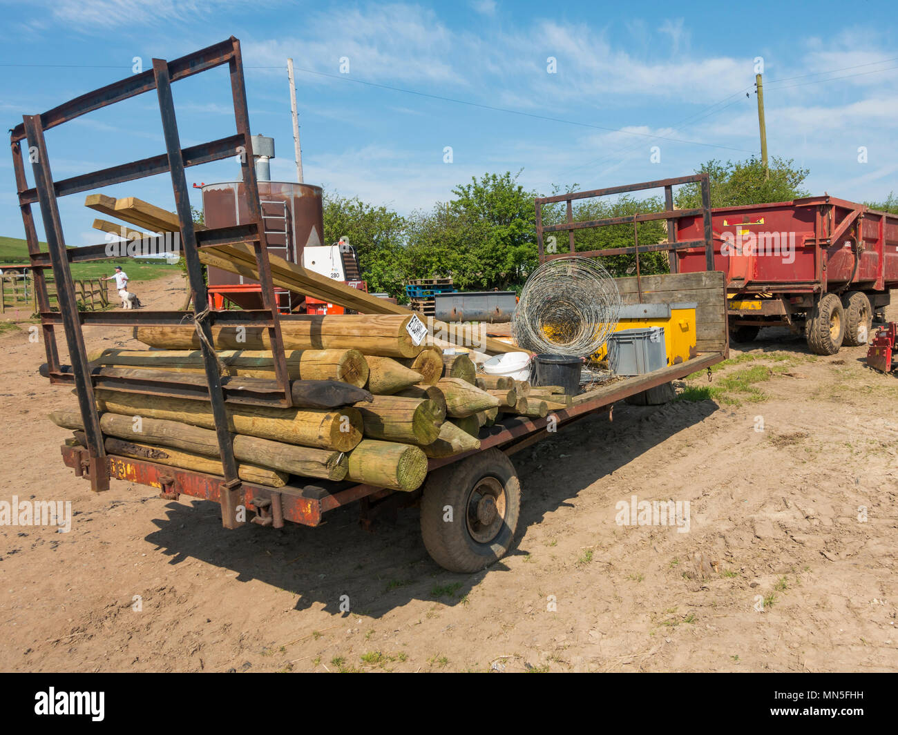 Un trailer de granja listo para usar la instalación de una valla con postes de cercas de malla de alambre laminado y herramientas de esgrima de stock Foto de stock