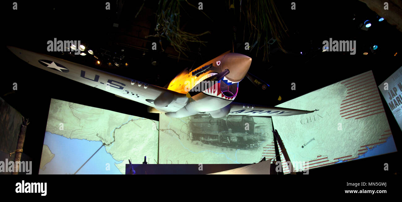 Un enorme tiburón enfrenta War Hawk P-40 fighter se sitúa por encima de las pantallas de vídeo gigante que muestra imágenes de las rutas de abastecimiento en tiempo de guerra a través de la montaña Himalaya Foto de stock