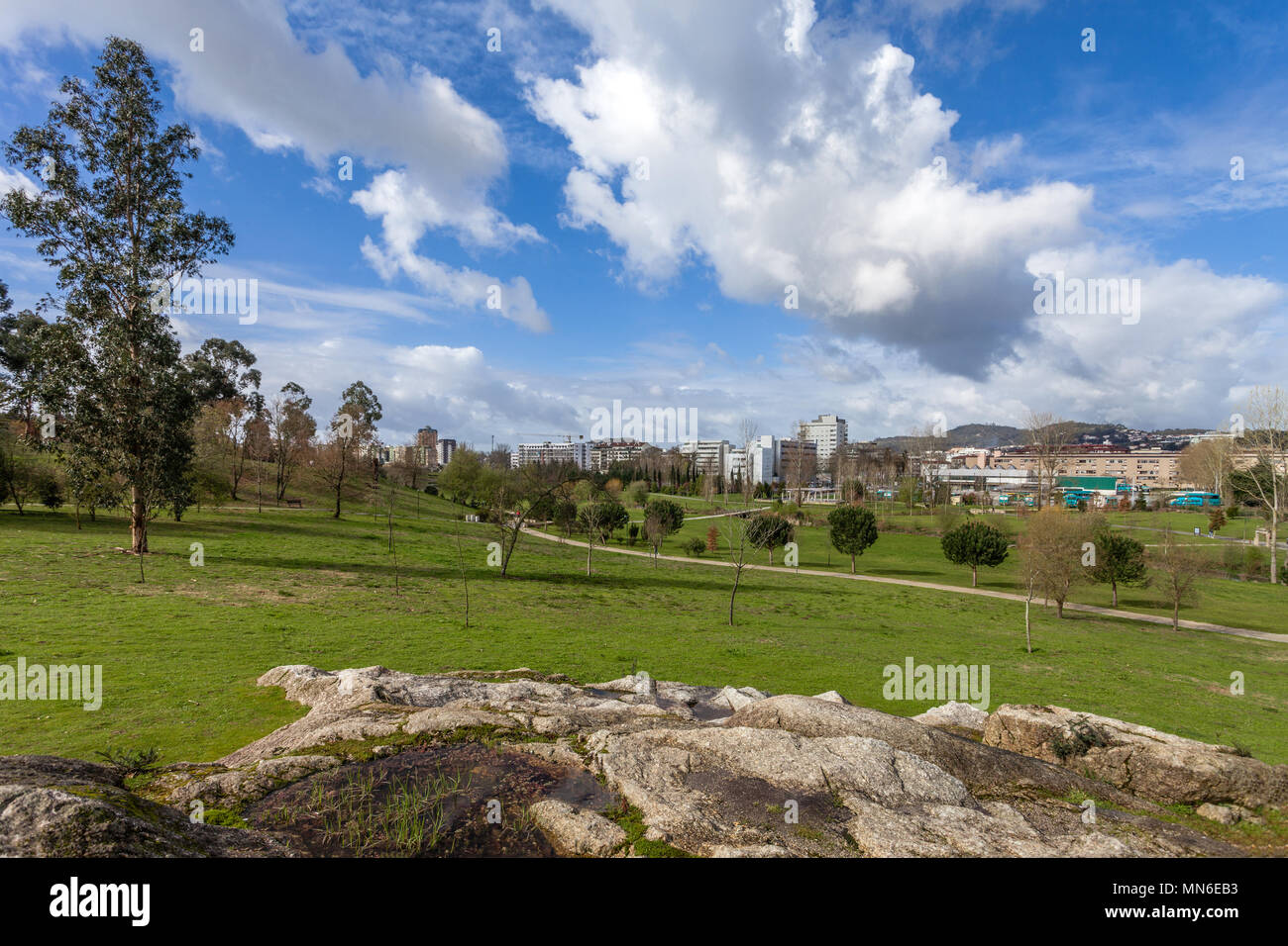 Gran césped verde campo vacío, con las vistas de la ciudad en el Parque da Devesa Parque Urbano. Blue Sky, grandes nubes blancas. Vila Nova de Famalicao, Portugal Foto de stock