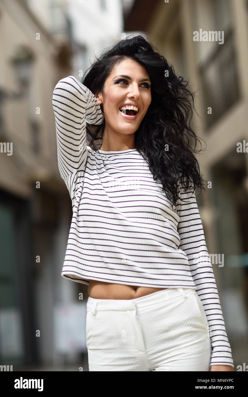 Una mujer morena modelo de moda casual vistiendo ropa blanca