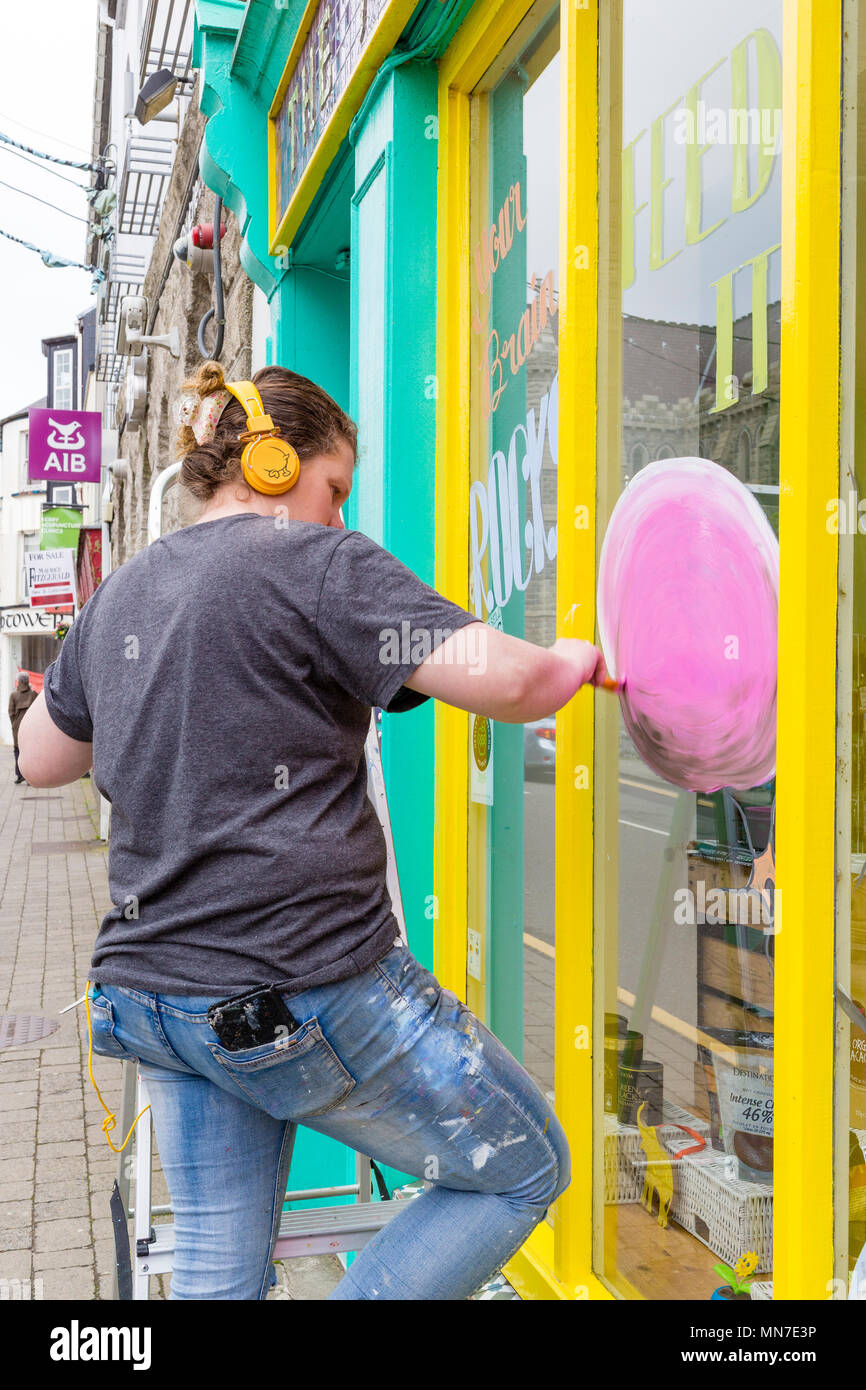 Signo de la mujer escritora pintar un escaparate, Cahersiveen, Condado de Kerry, Irlanda Foto de stock