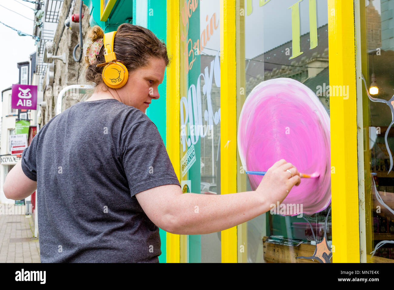 Signo de la mujer escritora pintar un escaparate, Cahersiveen, Condado de Kerry, Irlanda Foto de stock