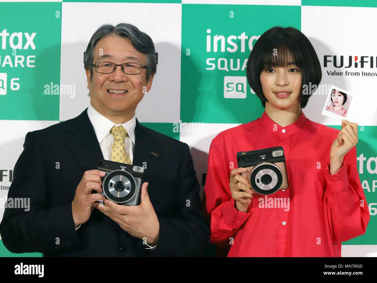 Tokio, Japón. El 15 de mayo, 2018. La actriz japonesa Suzu Hirose (R) y la  Cámara Japonesa Fujifilm presidente Kenji Sukeno gigante pantalla nueva cámara  instantánea Fujifilm instax SQ6 'cuadrado' en Tokio
