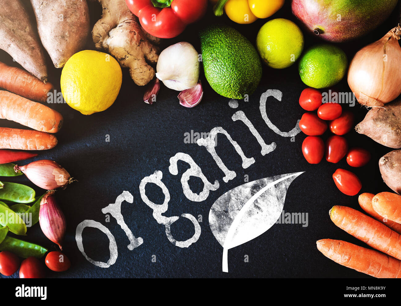 Directamente encima de acercamiento de verduras y frutas frescas orgánicas sobre fondo de pizarra con word organic Foto de stock