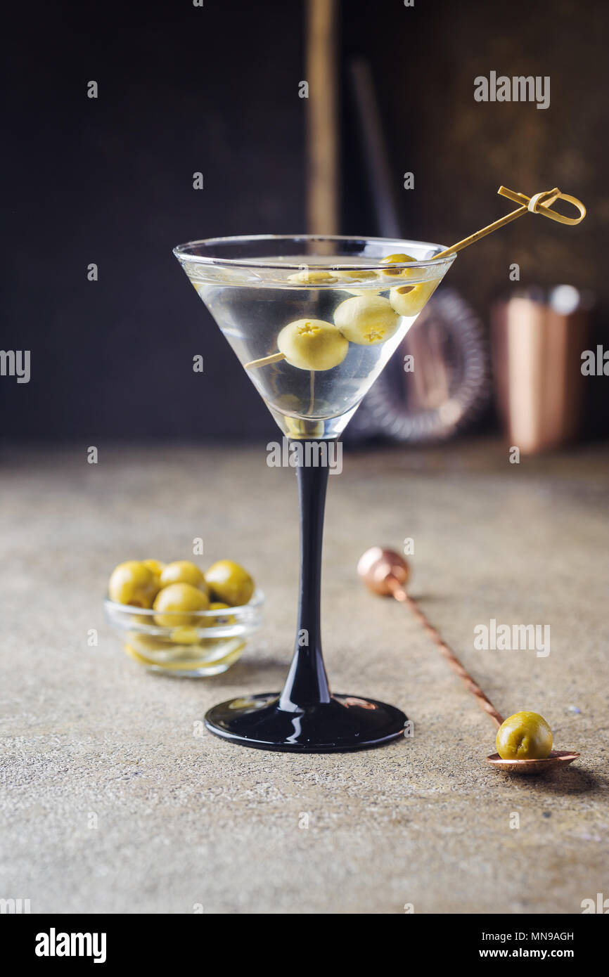 Coctel martini con aceitunas en piedra gris de fondo. Foto de stock