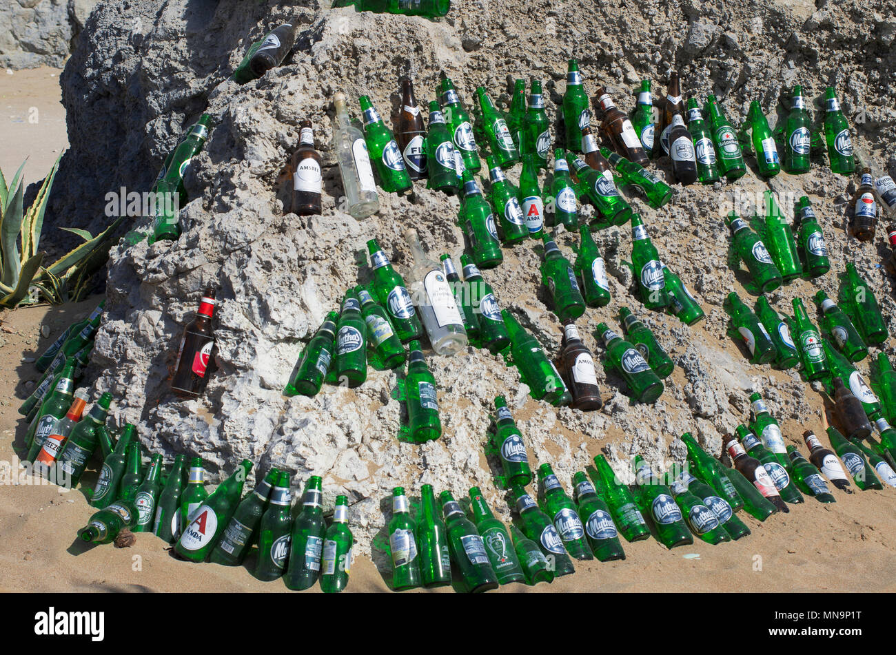 La playa de Tsampika, la isla de Rodas, Grecia - 21 de septiembre de 2017: hermosamente dispuestas las botellas de cerveza vacías sobre una enorme roca en un clima soleado. Marca Foto de stock