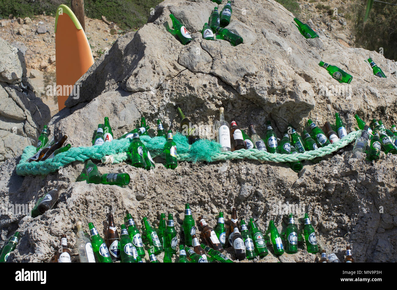 La playa de Tsampika, la isla de Rodas, Grecia - 21 de septiembre de 2017: hermosamente dispuestas las botellas de cerveza vacías sobre una enorme roca en un clima soleado. Marca Foto de stock