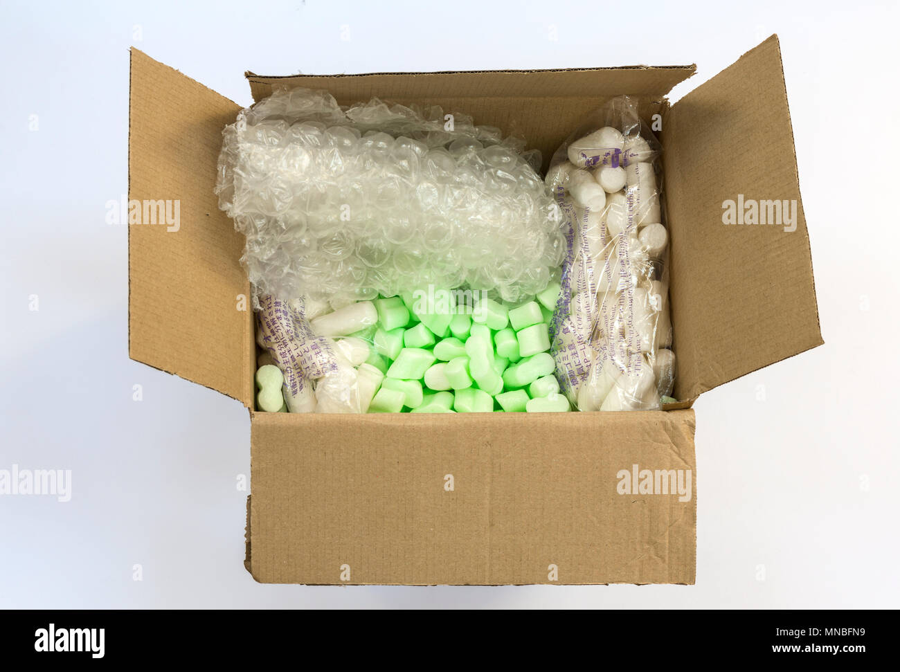 Caja con embalaje protector - fichas de espuma, plástico de burbujas, espuma de almidón de patatas fritas (derecha e izquierda). Foto de stock