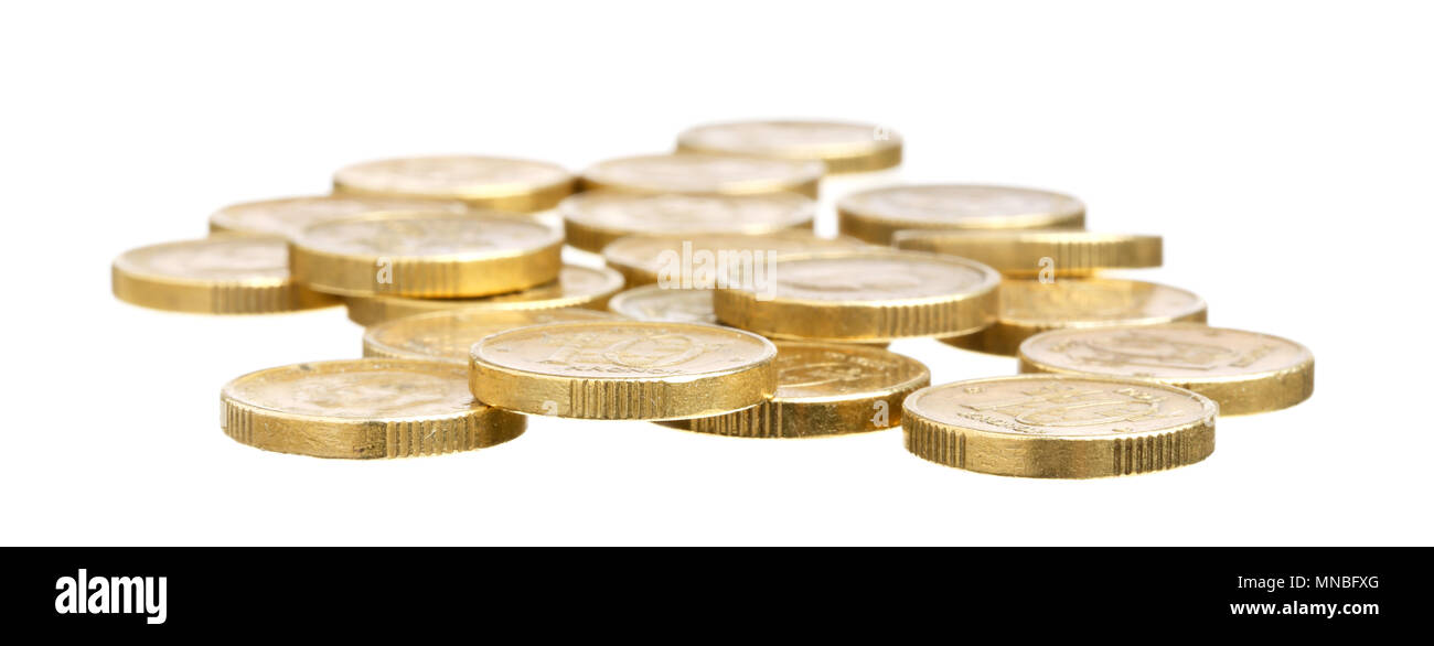 Monedas de oro aislado sobre fondo blanco con foco en primer plano. Foto de stock