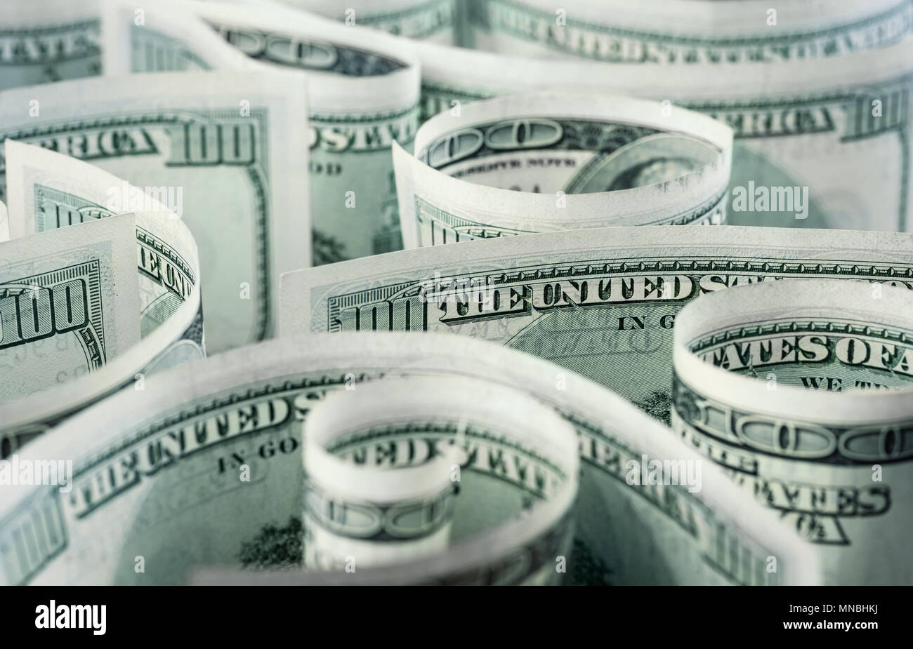 Billetes de dólar americano, laminados, curvadas en diferentes direcciones. Fondo de dinero. Foto de stock