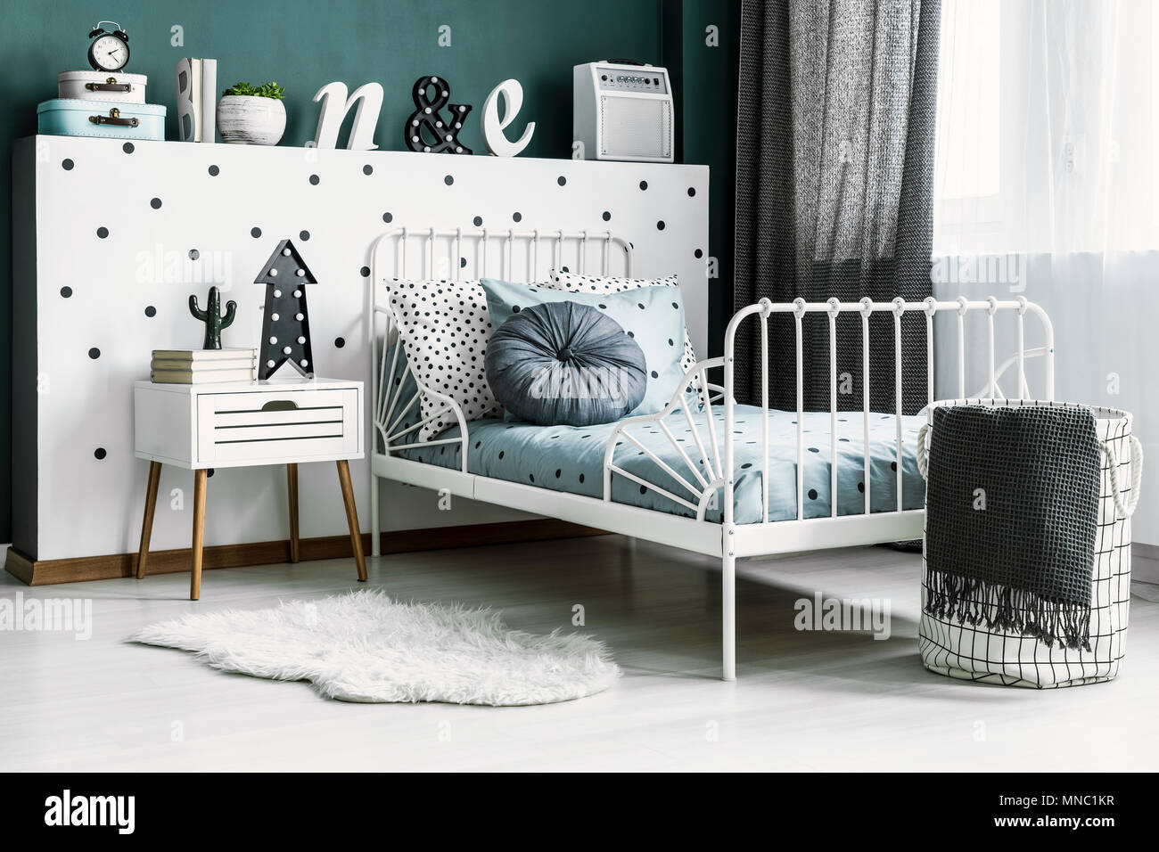 Ropa de cama estampada en la cama blanca brillante en el cuarto del niño  interior con piel junto al gabinete Fotografía de stock - Alamy