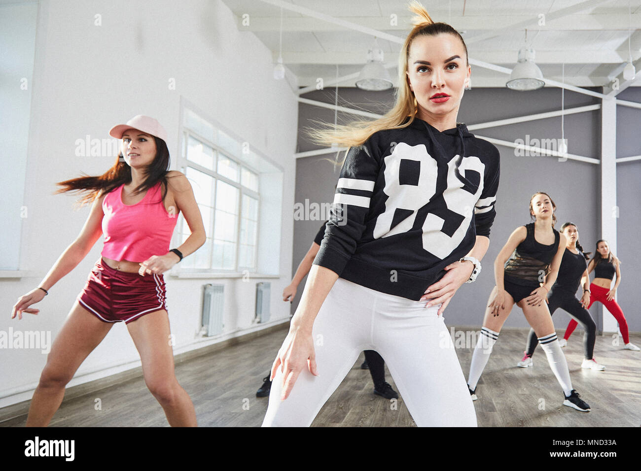 Seguros de mujeres jóvenes en ropa deportiva bailando en studio Foto de stock
