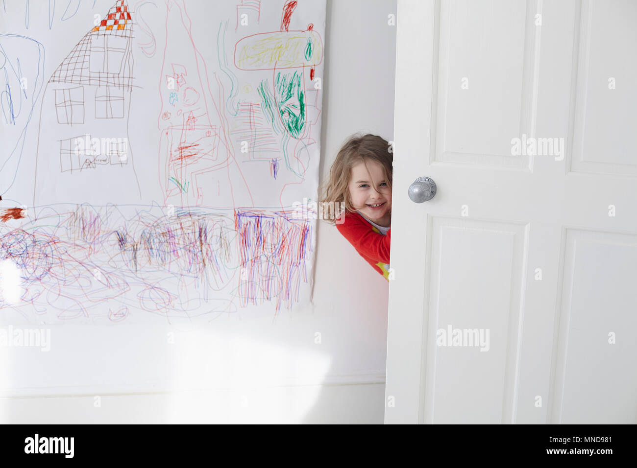 Retrato De La Alegre Nina Escondiendose Detras De Puerta Contra El