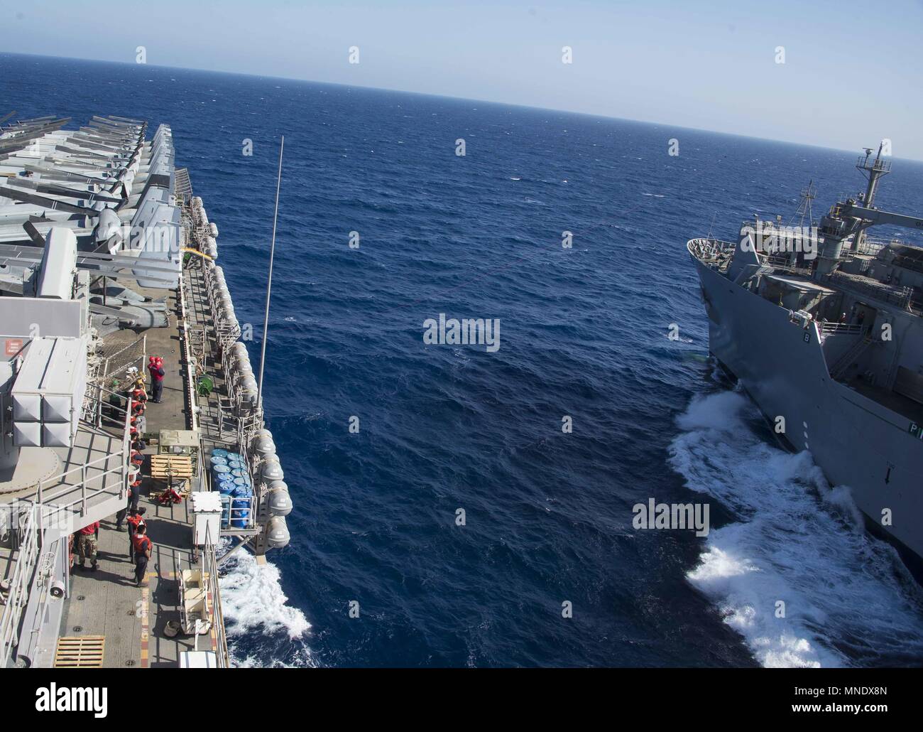 180515-N-AH771-0055 5ª Flota de EE.UU. ZONA DE OPERACIONES (15 de mayo de 2018) La carga seca y municiones buque USNS Amelia Earhart (T-AKE 6) recibe el teléfono y la distancia desde la línea de clase Wasp buque de asalto anfibio USS Iwo Jima (LHD 7) durante una reposición en alta mar, 15 de mayo de 2018, 15 de mayo de 2018. Iwo Jima, homeported en Mayport, Florida, está en el despliegue de la Quinta Flota de EE.UU. zona de operaciones en apoyo de las operaciones de seguridad marítima para tranquilizar a los aliados y socios, y preservar la libertad de navegación y el libre flujo del comercio en la región. (Ee.Uu. Navy photo by Mass Communication Specialist Foto de stock