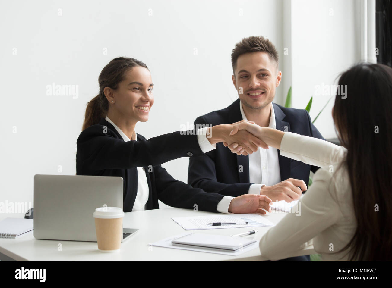 Representantes HR positivamente saludo candidato al trabajo femenino Foto de stock