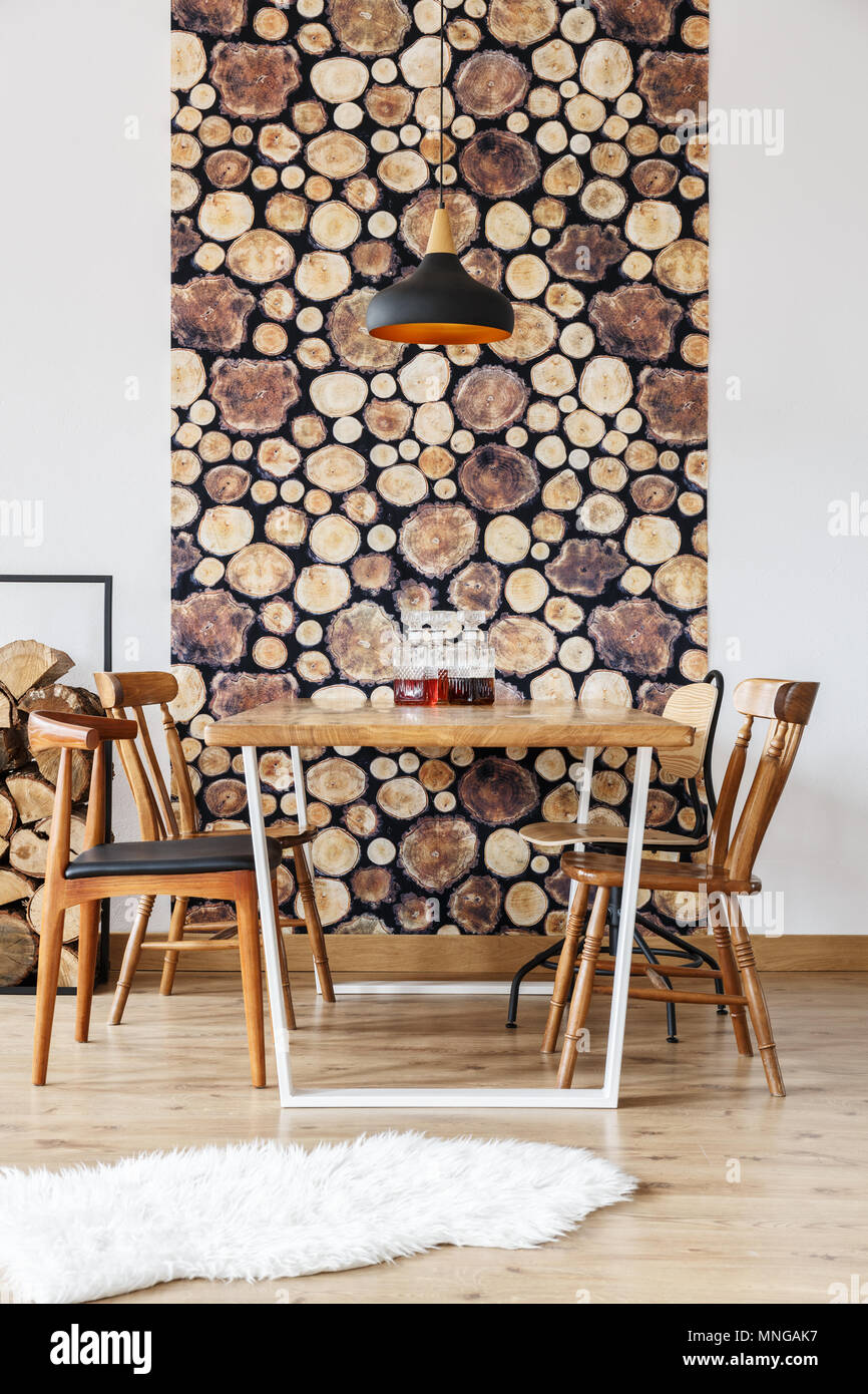 Diseño rústico y decoración de paredes de troncos de madera en estilo  moderno comedor con sillas negras y lámparas retro Fotografía de stock -  Alamy