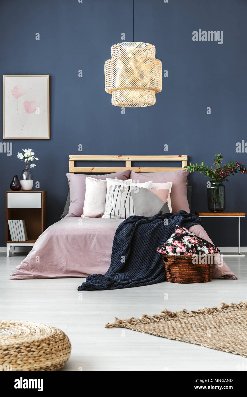 Habitación con paredes oscuras cojines decorativos y azul manta en la cama  de madera Fotografía de stock - Alamy