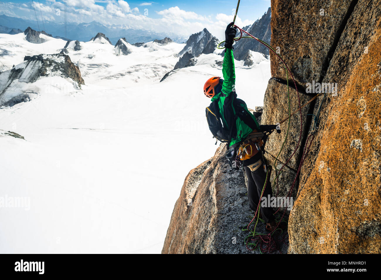 Vista lateral del escalador aventurero preparando para rappel desde la ruta de escalada, Aiguille du Midi, Haute-Savoie, Francia Foto de stock