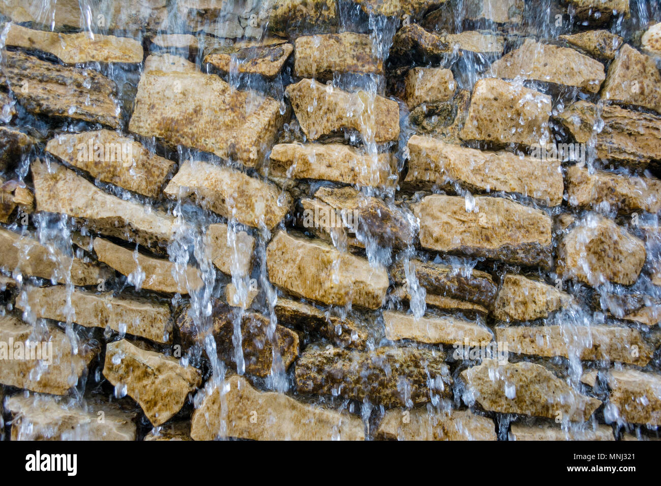 Cascadas que descienden los derrames y la pared de roca closeup Foto de stock