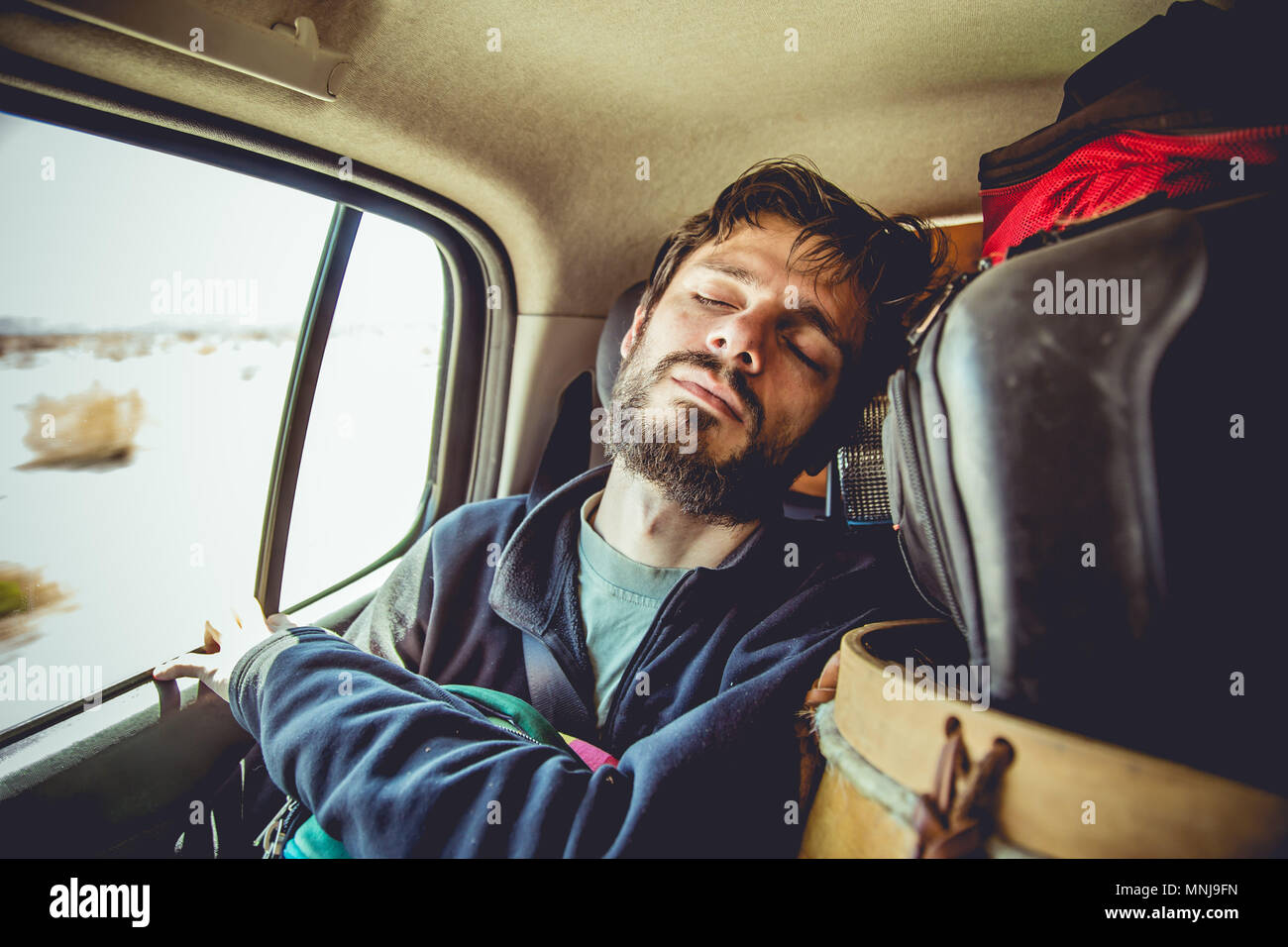 Hombre durmiendo en el coche durante el viaje Foto de stock