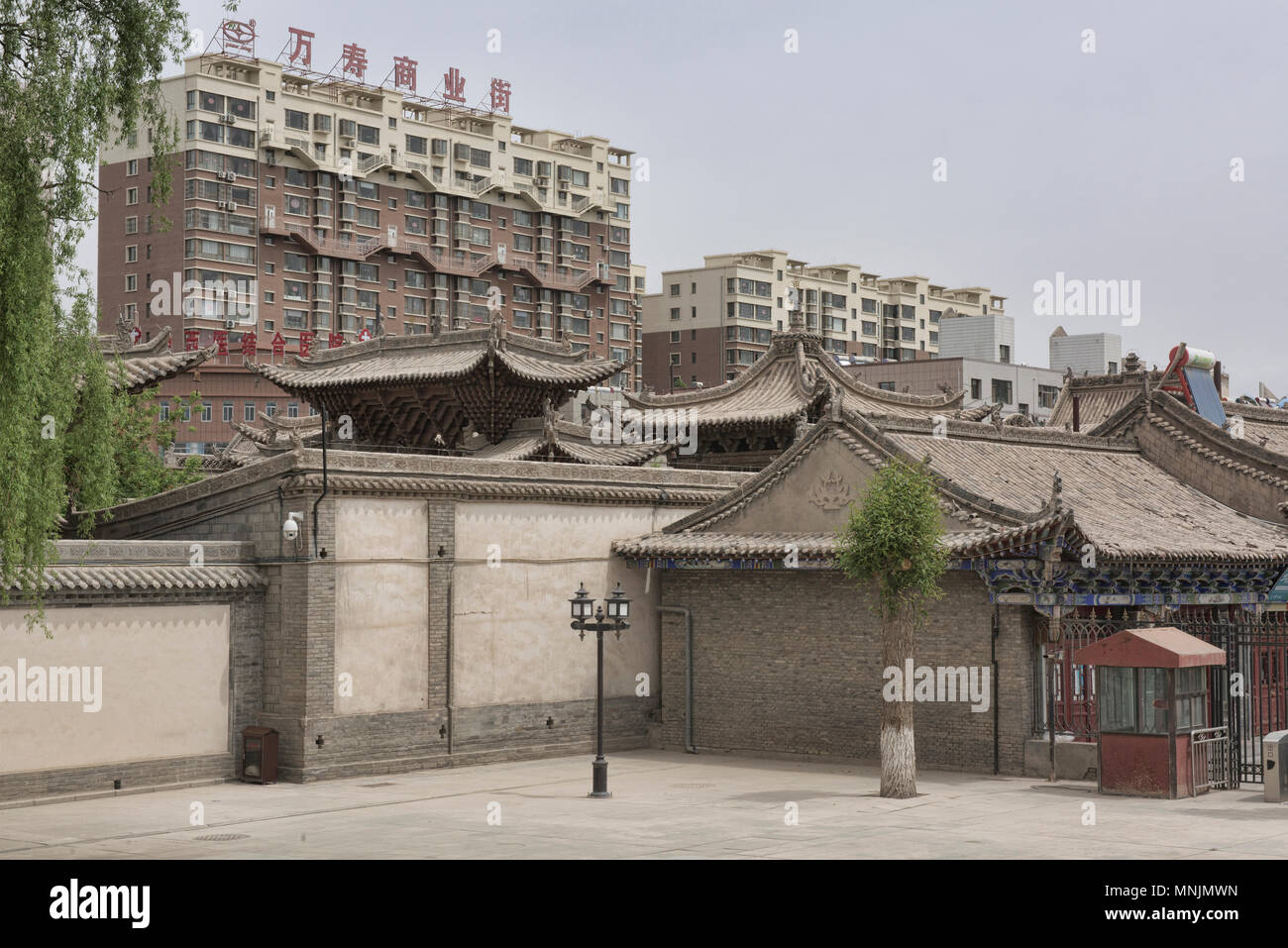 Lo viejo y lo nuevo, Dafo Templo con rascacielos detrás, Zhangye, Gansu, China Foto de stock
