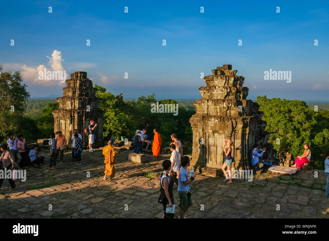 Los turistas esperando en las torres de piedra en la terraza superior del templo de Phnom Bakheng piramidal para ver la vista panorámica de la puesta del sol. Foto de stock
