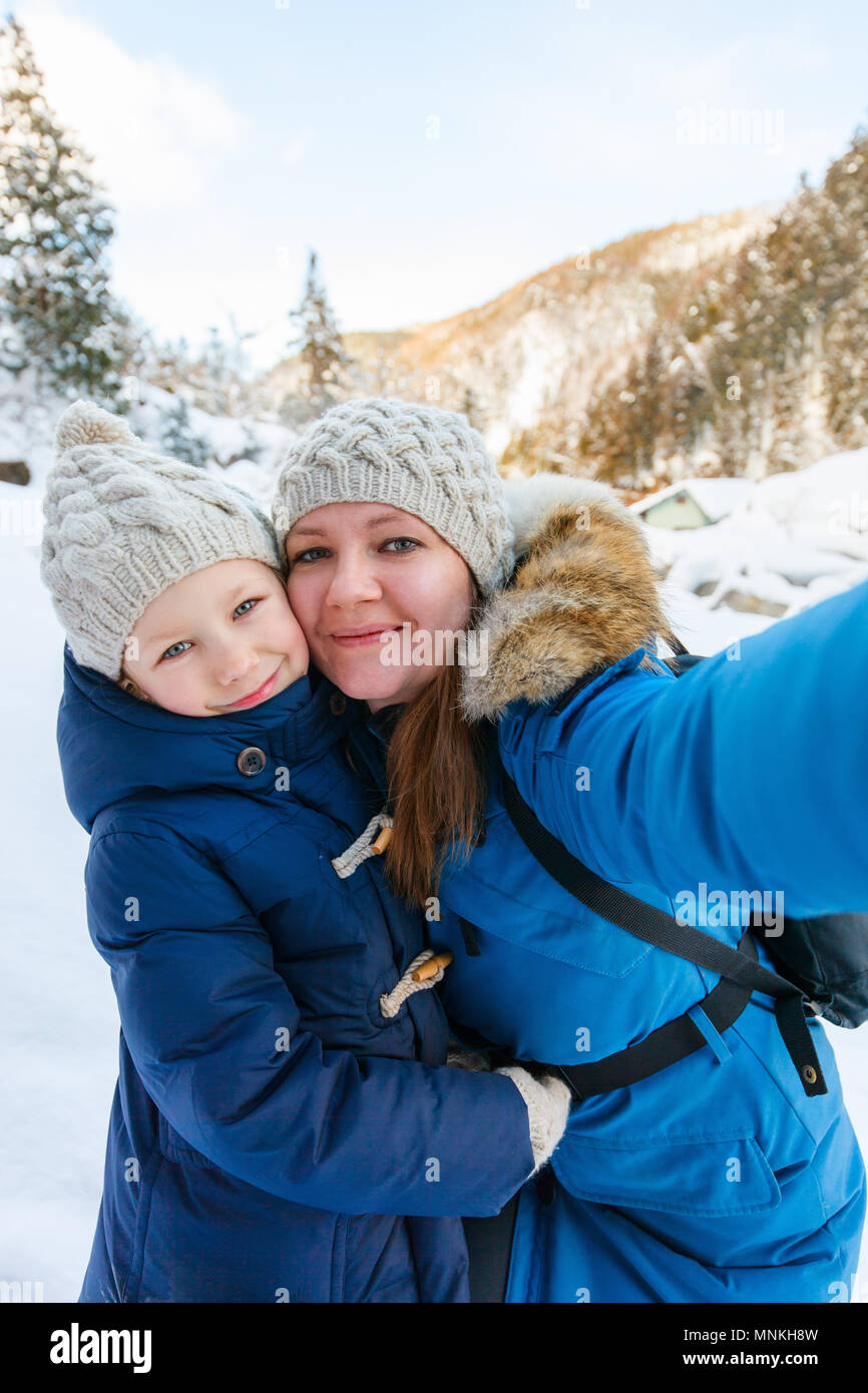 Madre e hija teniendo selfie en el hermoso día de invierno al aire libre Foto de stock