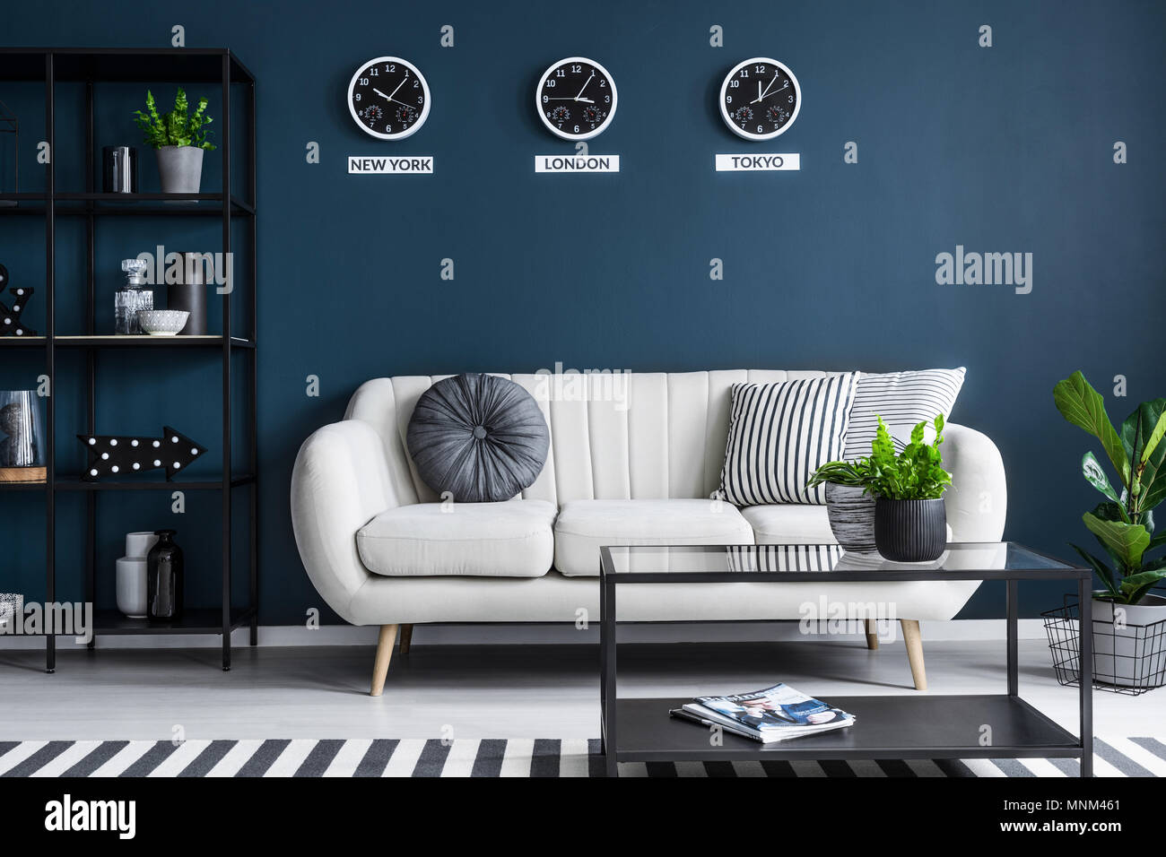 Elegante sofá en beige, azul marino oscuro salón interior con muebles  negros y elegante decoración Fotografía de stock - Alamy