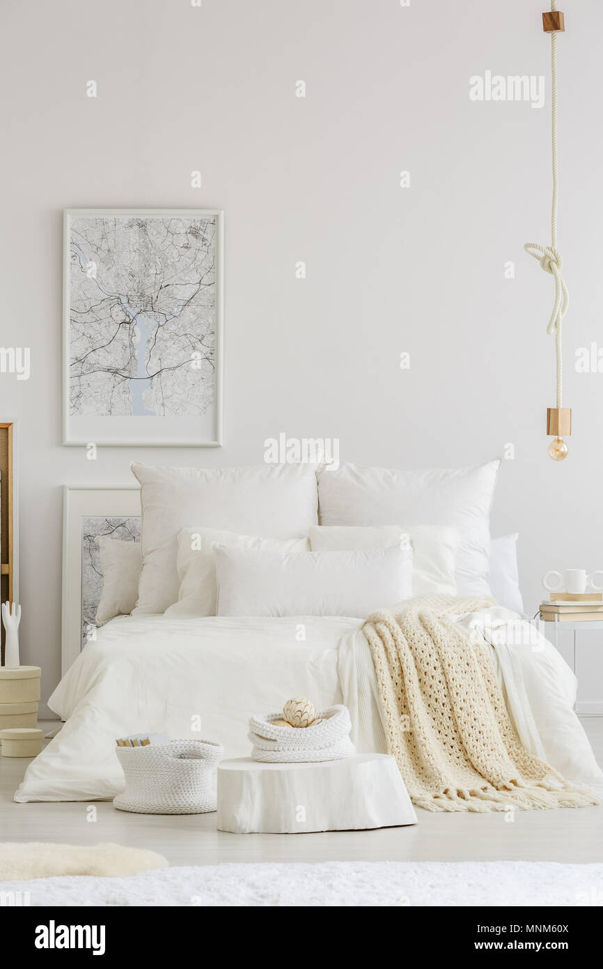 Ropa de cama blanca y cobija tejida en una cama king-size en Nordic  permanente habitación interior con un cartel en la pared Fotografía de  stock - Alamy