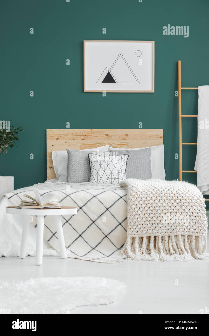 Póster en blanco y negro colgando sobre la cama con sábanas blancas en el  interior de la habitación verde Fotografía de stock - Alamy