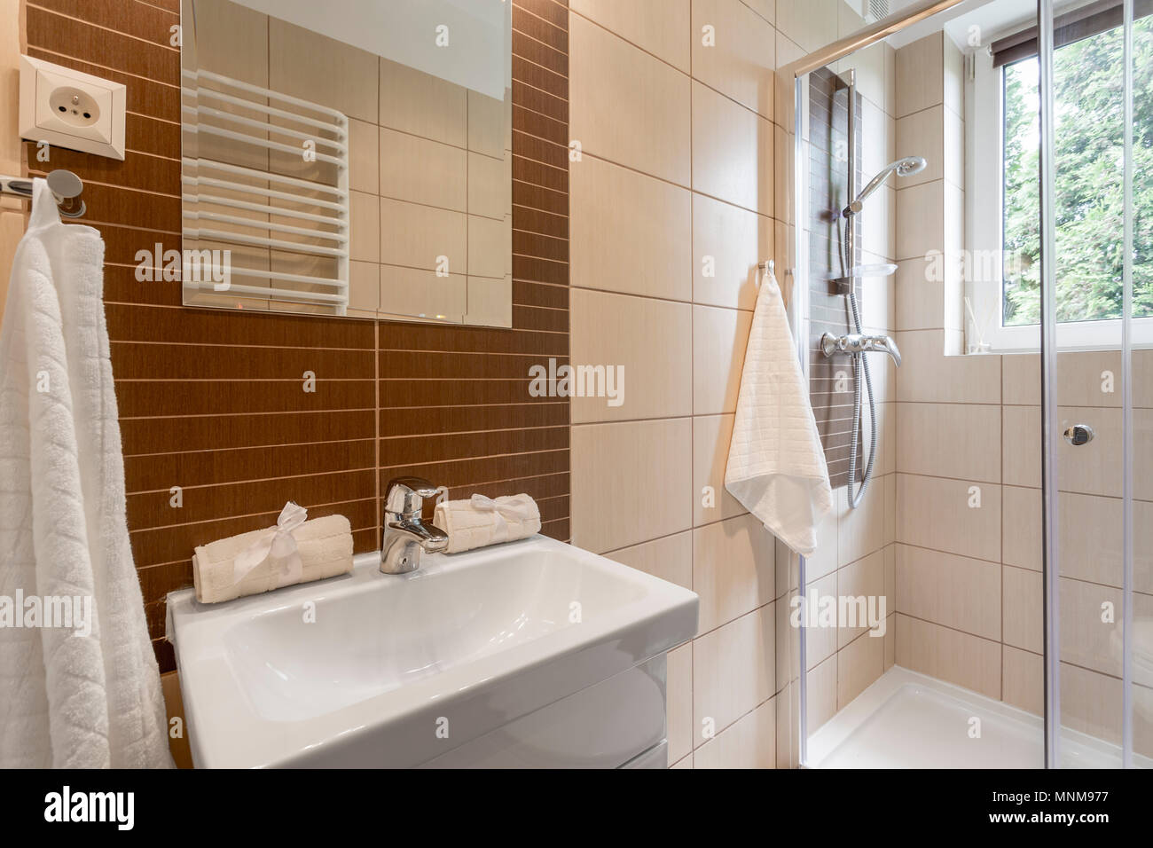 Pequeño cuarto de baño con azulejos marrones, espejo, ducha y lavabo  Fotografía de stock - Alamy