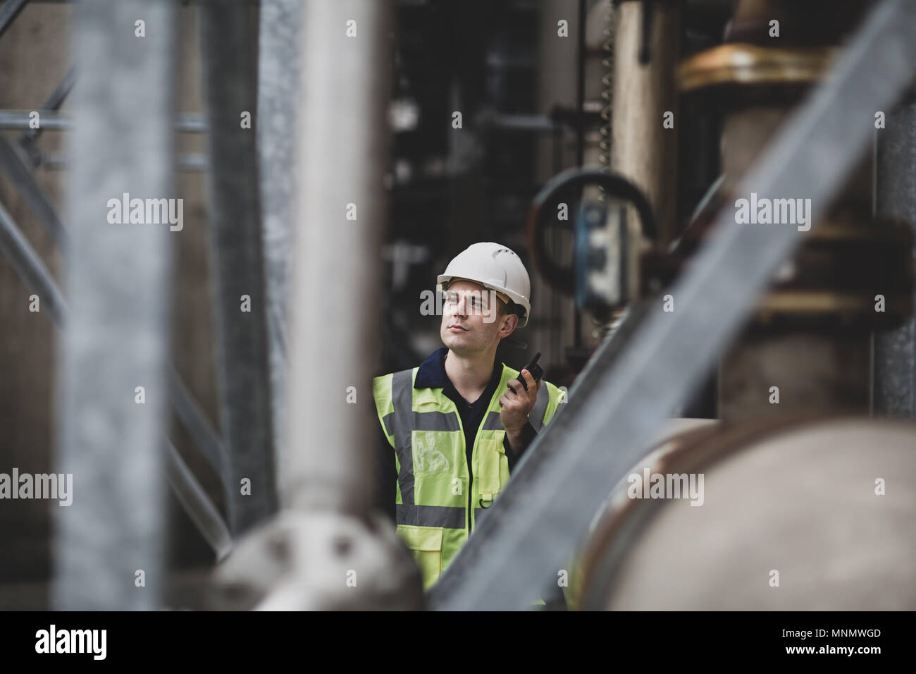 Trabajador industrial utilizando la radio en el sitio Foto de stock
