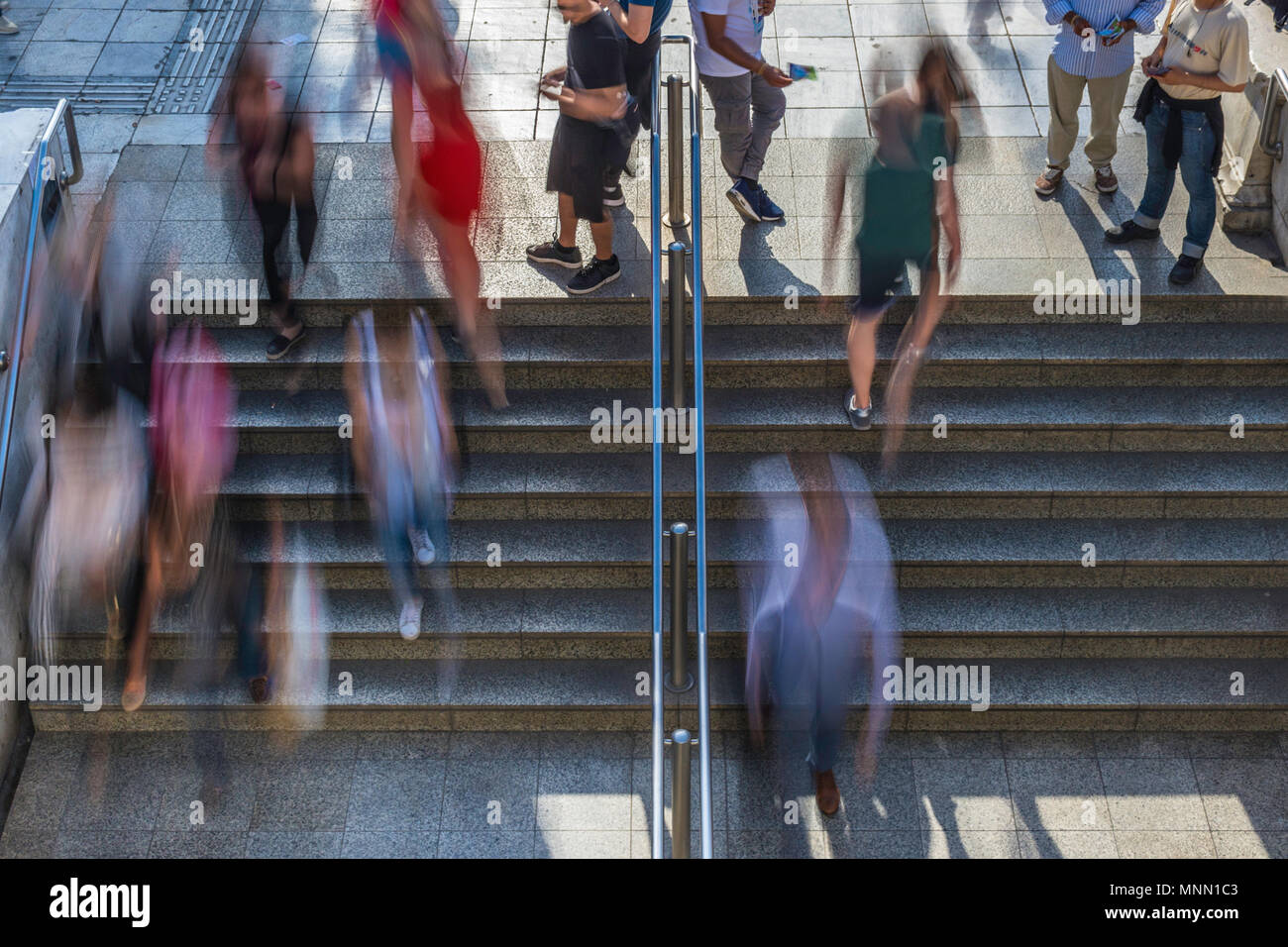 Sobrecarga de gente borrosa subir y bajar las escaleras entrando y saliendo del metro Foto de stock