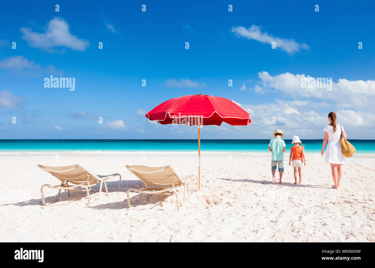 Dos sillas bajo el paraguas en una hermosa playa tropical con familiares  cercanos caminando Fotografía de stock - Alamy
