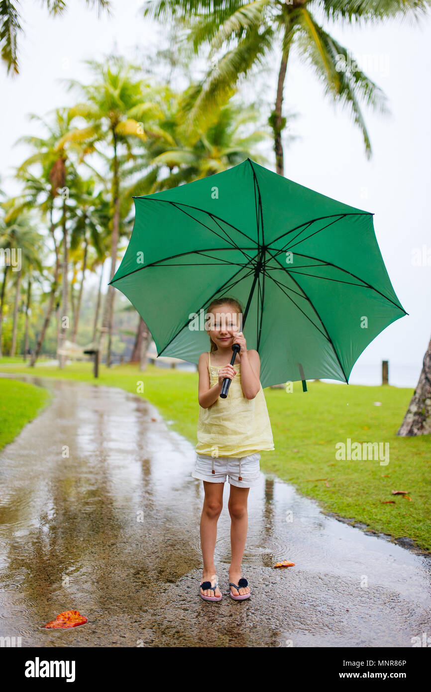 Adorable niña con gran paraguas verde al aire libre en días lluviosos  Fotografía de stock - Alamy