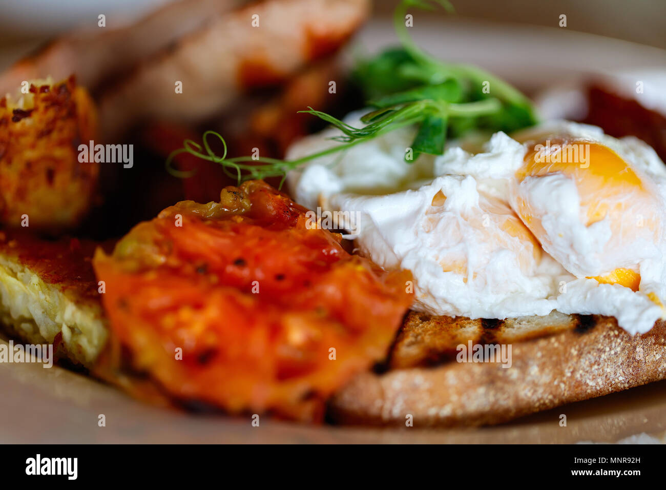 Delicioso desayuno con huevos fritos, tocino y verduras Foto de stock