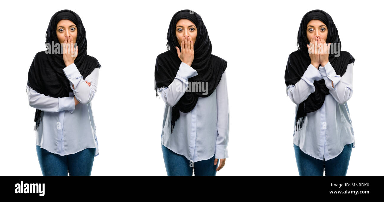 Mujer Árabe llevar hijab cubre boca en estado de shock, parece tímido, expresando el silencio y confundir los conceptos, asustada aislado sobre fondo blanco. Foto de stock