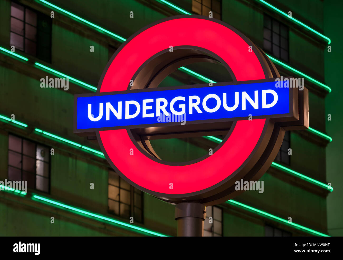 Señal del Metro de Londres iluminado en la noche, Londres, Inglaterra, Reino Unido. Foto de stock