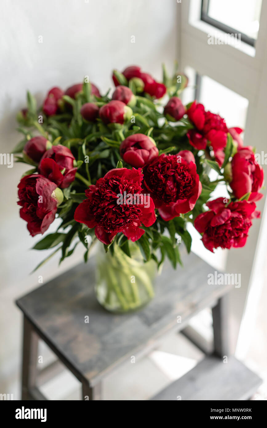 Hermosas flores en jarrón de cristal. Precioso ramo de peonías rojas .  Composición floral, la escena, la luz del día. Papel tapiz Fotografía de  stock - Alamy