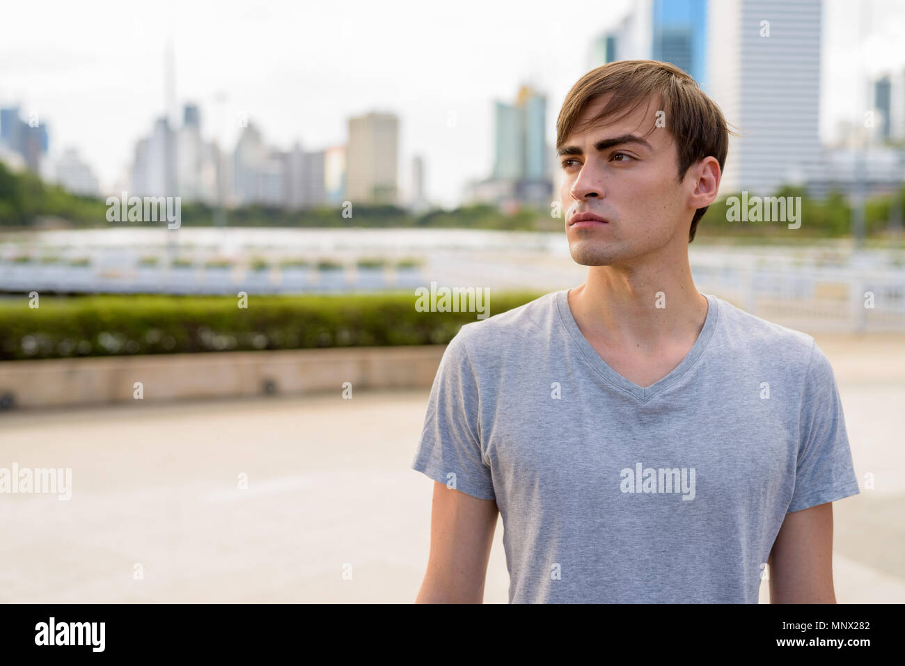 Joven apuesto hombre descansando en el parque Foto de stock