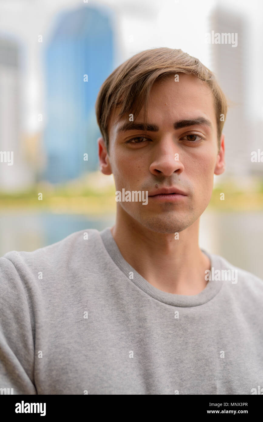 Joven apuesto hombre descansando en el parque Foto de stock