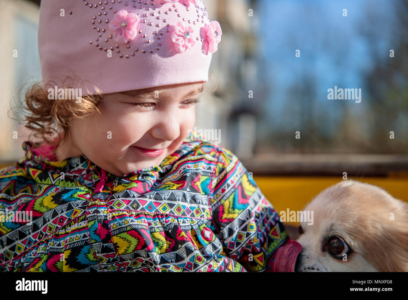 Pequeña y dulce chica con un perro mullidas Foto de stock